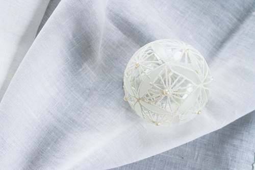 home decor white lace Christmas bauble on white garment linen